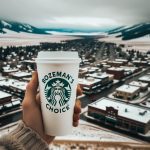 Hand holding Starbucks cup saying Bozeman's Choice over the city